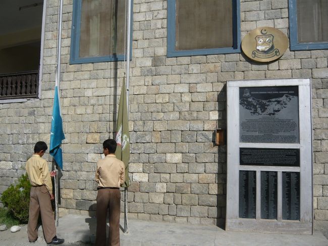 ここでは毎朝国旗の掲揚がなされています。ポール横の壁面には、長谷川恒夫さん、奥様の紹介文等が記載されたプレートが設置されています