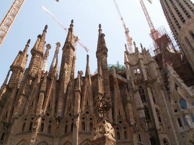 「後陣の外観」<br /><br />後陣の外観を見るとガウディがとても自然を愛していたことが分かります。<br />ピクナルの先端には麦の穂や花が配されています。<br /><br />背の高い塔の一番右のピクナルの下にはキリストのアナグラムが施されています。<br /><br />右から２つ目のクレーンの真下にある比較的新しい塔の外壁側面には螺旋階段があるいことを示唆するカタツムリと巻貝が取り付けられています・・・が、う〜ん、分かりづらい・・・。<br /><br />