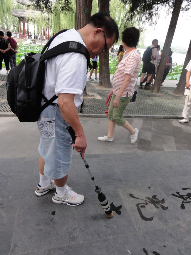 水を含ませた筆で文字を書く人が数人いました。<br />