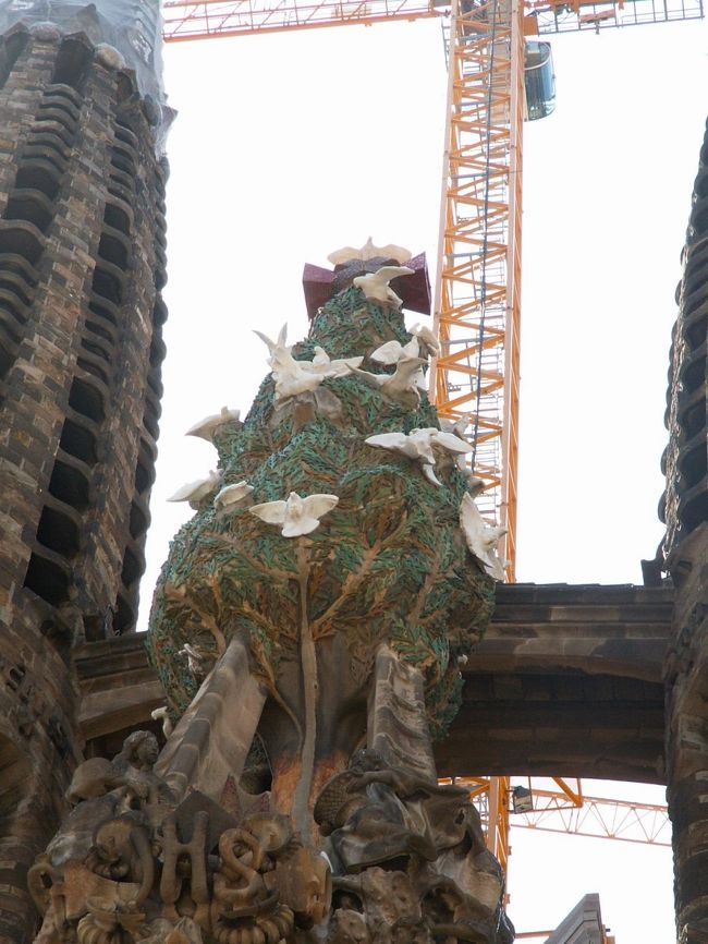 糸杉にたてかけられた２本の梯子は、神に近づこうとする思いを表しています。<br /><br />さらにその下にはイエス・キリストを表す「ＪＨＳ」の文字が十字架の上にあしらわれています。<br />イエスがすべての始まりであり、終わりであることを示しています。