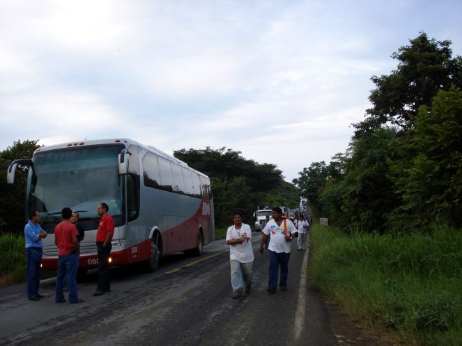 私達が乗ってきたバス。歩いていけるようなところではない遠く前方で事故が起きて、道路を塞がれたせいか対向車線からは車が来ないので人が道路の真ん中を歩いて1〜2Ｋｍ程のところにある食堂や店に買物に行く人がいた。<br />