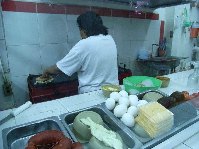 食堂のオバサンがチュリソーのハンバーガーのようなものを調理しているところ。<br />