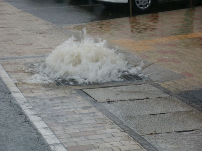 秋田からの走行中今年よく目にする流行？のゲリラ豪雨に遭遇し、にかほ市に入って目にした光景は浄蓮寺側道で溝から吹き出している雨水。