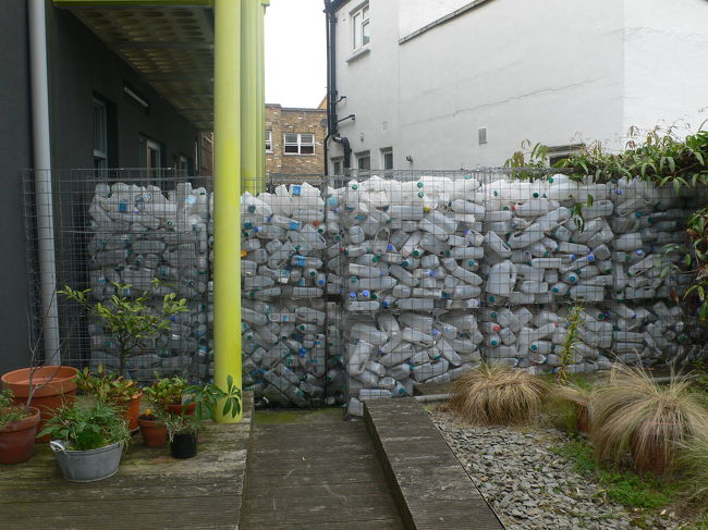 キッチン＆書斎横のテラスと入り口の間仕切りにはプラスチック容器が使われていました。<br />キャップがカラフルだし、いいかも。