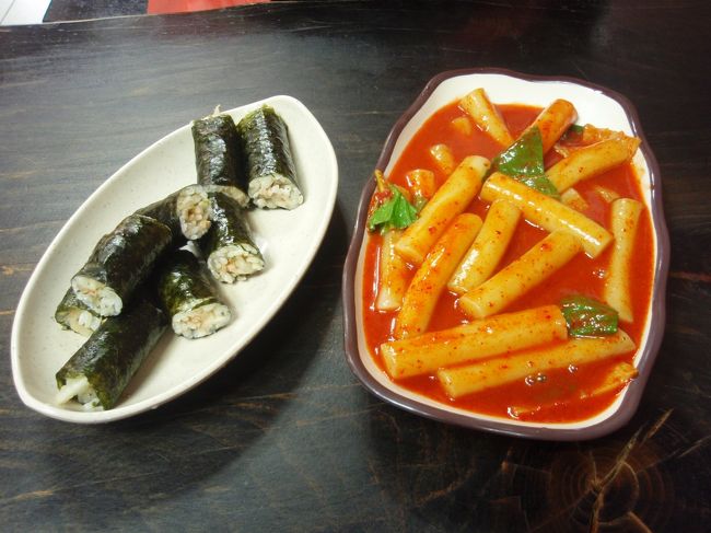 2日目の昼食に、弘大の街中で食べたキムパッとトッポギ。<br />各2500ウォンでした。<br />街をぶらぶらしていたら、ちっちゃいお店を見つけて、もちろん日本語も英語も通じず、現物の指差しで注文をしました。<br />おじさん、いい人でした。<br />壁にメニューと価格が掲示されていたので、持っていたガイドブックとメニュー名を見比べ「同じ記号(文字なんですけどね・・・)を探せ!」と、言わんばかりに探して、価格を見ました。<br />「ん?　よくよくみたら2500ウォン均一じゃない?」<br />ちょっと気づくのが遅かったけど、美味しく楽しめました。