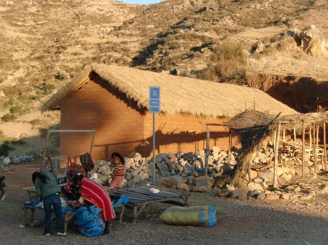 峠には土産物屋があり、民族衣装を着た人々が（数少ない観光客？）を待つ。夕方になってきたので店仕舞い（写真）をしている。