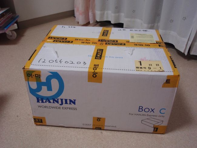 ここからは、私の購入ものリストです。<br /><br />龍山のイーマートで購入し、その場で宅配をお願いしました。<br />写真は到着時です。郵便局の人が持ってきました。<br />7.6キロの荷物で、36000ウォン。約2500円くらい。<br />3日ぐらいで届きました。<br />ビンに入った胡麻油も買いましたが、ちゃんとプチプチでくるんでくれました。<br />日本語OKのカウンターですので、お手軽です。<br />この価格で楽ちんに帰れるならお勧めの方法です。<br /><br />担当の女性の人が、「せっかくだから・・・」と<br />箱に、私の名前をハングル文字で書いてくれました。うれしいです。<br />