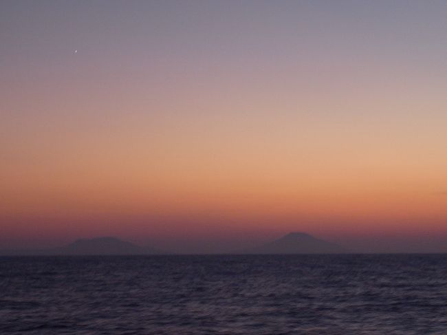 伊豆七島からはちょっと離れたルートを通っているのか、船からその島影をみることはできませんでした。<br />が、日も暮れたオレンジと紫色の空と海の間にもやーっと八丈島の姿がぼんやり望めました。