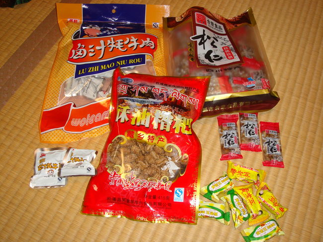 バラマキ用おみやげです。<br />左から、九寨溝名物、ヤクの肉です。1.5cm角のビーフジャーキーみたいのが、小分けになってます。<br /><br />中央･･･どこかのホテルの朝食にあって美味しくて探して買いました。蓮の実の砂糖がらめ。<br /><br />右上･･･これも四川名物。くるみゆべしみたいなのです。現地ガイドさんのパンフレット販売では、16個で６０元ですが、空港やスーパーでは４５個入りで２０元くらいからで小分けになっているものも売ってます。<br /><br />右下の黄色いのはもうバラしてしまったんですが、ピーナツキャンディ。<br />これもスーパーでは20元以下で50個入くらいのがあります。