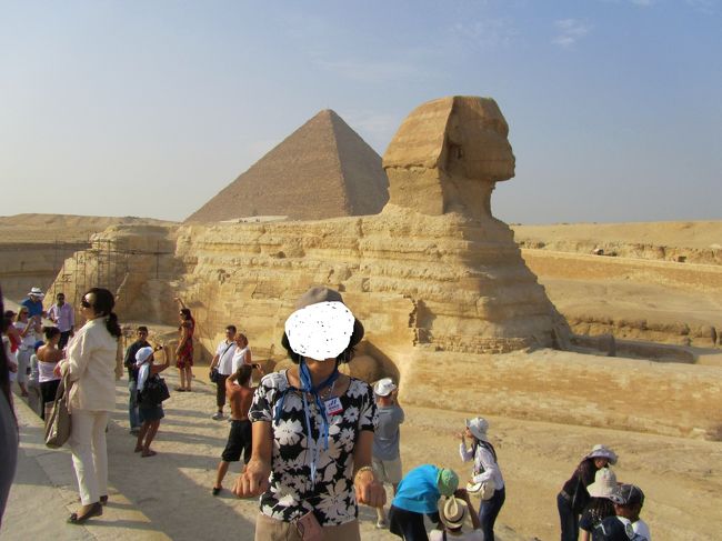 この手は｢スフィンクスのポーズ」と呼ばれます。(笑）<br /><br />他には頭の上で手を三角にすると「ピラミッドのポーズ」、<br />手を胸の前で×の形にすると｢ミイラのポーズ」です。<br /><br />スフィンクスとキスしたり、ピラミッドを手の上に乗せるのも定番ですね。