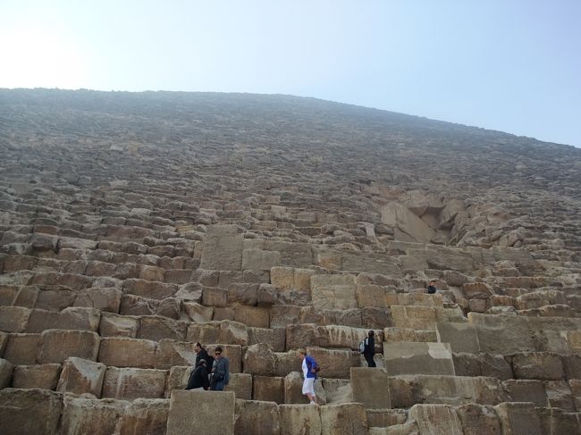 　さぁ、ピラミッドの中に入っていきます。このピラミッドを構成している石を登っていかなくては入り口に辿り付けません。<br /><br />　さて、ガイドブックには、このピラミッド地区に入るには入場料が必要で、かつ何度も言ってますようにクフ王のピラミッドの入るには先着３００人の枠に入る必要があり、もちろん入場料も必要と書いています。<br /><br />　が、「大丈夫です。ピラミッドに入れます。」とばかり言うガイドに付いて来たけど、ここまで入場料を払った覚えは無い。それに、ピラミッドの入り口で、係員に何かを渡したかと思いきや、すんなりどうぞと、ピラミッドの中に入れてもらえました。<br /><br />　うーむ、入れたからあまり詮索したくないけど。。。エジプトの現実なのですね。これが。