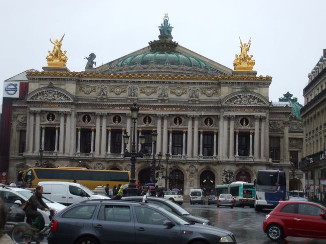 「オペラ座正面」<br />オペラ通りを少し下って振り返ると、オペラ座の青いドーム、屋根脇の黄金の天使像が燦然と現れた。雨のなかでも輝いている。オペラ座はこうでなくちゃアカン！今まで近すぎて見えなかったのである。華麗、荘重みごとなもんである。
