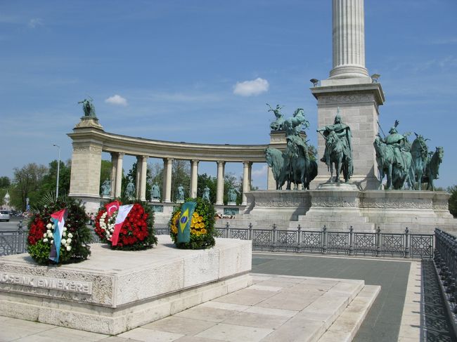 　記念碑の足元には、ブラジル、トルコ等の旗が付いた花輪が置かれています。<br />碑の下の騎馬像は７人のマジャル族の首長、周りを囲む像はハンガリーを代表する１４人の英雄だそうです。