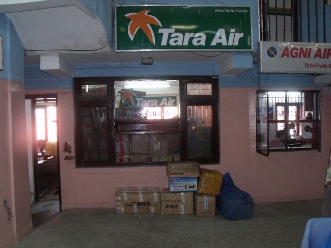 ガイドいわく、TARA航空はイエティの子会社で、３機保有している。今日は天気が良いので、３回は飛ぶ。３×３×２０人で１８０人は運べると言うが、全然登山客風の人たちは減らない。３機のうち２機はデワァり客のほうにとられているに違いない。<br /><br />空港内には売店も、トイレもない。そんなはずはないと思ってよく見ていると、<br />カウンターや重量計をまたいで中に入り込まなければいけない。２階にある小さなレストランもまたがないといけない。まるで従業員のためのもので、乗客が使いやすいようにはなっていない。<br /><br />TARA航空の事務所は物置になっている。重量計で体重を測る。７８KG服や重い登山靴を履いているので７５KGというところか。この先どんな苦労が待っているのか楽しみだ。