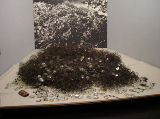 第5ブロック内：囚人のメガネ<br /><br />-コラム：ナチスの思想-<br />ナチスの思想の根本には、反ユダヤ主義・反民主主義・反共産主義とドイツ民族の優越がありました。また「人種的に純粋」な社会を築こうとし、ナチス・ドイツはユダヤ人の絶滅そしてスラブ人とジプシーとその他の民族の絶滅を計画していました。<br />ポーランドへの進行による第二次世界大戦勃発の目的の一つには、ドイツ人が移住するためのドイツ領の拡大がありました。1937年にドイツ第三帝国の権力者と1933年にドイツ政権を執ったNSDAPの設立者であったアドルフ・ヒトラーは次のように語りました。<br />「我々の戦争目的は、人を勝ち取ることではなく、農業に適する領域を勝ち取ることである。」