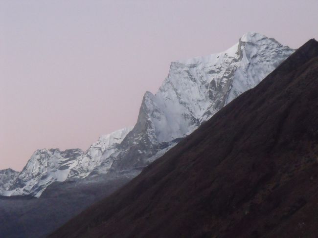 東京混成隊はナムチェで高所順応のためもう１泊すると言う。当方はゴキョウで２泊する予定だから、そこでまたお会いしましょうと別れる。<br /><br />１１：５０発<br />１２：１５クムジュン　宇宙図の貼ってある所で昼食シャンボチェより下ってきたように思うが、クムジュンは３７８０Mで、シャンボチェ３７２０Mよりもい。<br />村の屋根はグリーン色に統一されている。屋根の水をタンクに集めて使っている。<br />雨樋いからタンクにはペットボトルの２リットルをうまく使っている。あんな簡単なもので済むなんて、風も雪も吹かないのだろう。アップルパイとお茶だけで済ます。<br /><br />ナムチェが品川なら、クムジュンは田園調布とは誰が言ったのやら植村直己氏が越冬した。<br />植村直己さんのお兄さんは私と同じ畳屋だった。直己さんも畳屋の息子だったのかな？<br /><br />クンビーラ（標高５７６１ｍ）。村人は水の神が住む山として信仰している。<br />雪解け水が畑をうるおし、飲み水となっている。日本の金毘羅さんの本家雨乞いの神として、農民の信仰も厚いものがある。古来、雨乞い祈願の神というのは五穀豊穣をもたらす神でもある。特に、雨が少ない地方では、田植えの時期に旱魃に悩まされることが多く、農民たちは金毘羅さんにお参りして雨を祈った<br /><br />１３：２０合流地点　ここまでずーとくだり。ここから上ったり下ったり。