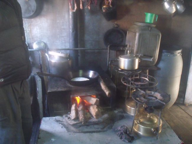 大きなラジュースとかまどで煮炊きしている。後ろのタンクは温水シャワー用で、かまどの中へ配管されている。<br /><br />トイレはブツに葉っぱをかけて、横にある棒で、山になった物を鳴らす。意外と臭くなく、葉っぱの香りがする。畑の土は黒土だ。１１月５，６，７日が３連休になっている。６日にルクラからカトマンズに帰る日だ。また悲劇の再演になりませんように。