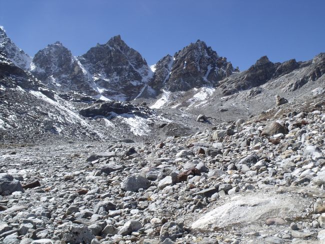 １１：３５峠のケルンと思っていた所を通っても、まださきがあった。<br />１１：５５やっと着いたと思ったらまだ先があった。懸垂氷河が普通の氷河に代わっている所。ここで引き返す人は賢い。出ましたツウェンティミニッツ。２０分たった頃、ワンアワーズ。<br />誰がお前の言うことを信じるものか。<br /><br />１２：４５ビスケットをカラスと分ける。ここで帰った人も賢い。クリシュナよお前先に行って、<br />帰ってこいよ。１時間で帰ってきたら俺行くよ。と弱音を吐く。<br />２：１５遠くからでも見えていた恐竜のひれみたいなところが峠だった。ここまで上がってきた人はアホ。来たからには帰らなければならない。<br /><br />