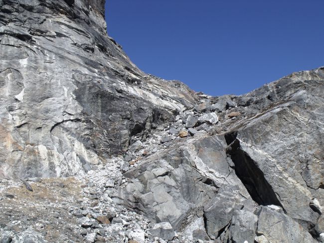 １０：３５青氷になって、つるつるの恐ろしい所を慎重に下り、５１９０Mの岩棚まで降りる。<br />ケルンがあり、岩屋もあった。<br />１１：２０給水分放水　振り返れば岩肌をトレースしてきた。５０９５M地点居候でなかったら、<br />昼寝をしたい心地よさ。<br /><br />１２：１０　どんどん下り、４８５５M地点　8度　どのルートでで下ってきたのか、<br />Zの字状に下ってきたようだ。あと30分でロッジに着く頃になって、ばててしまった人がいる。<br />いわゆるシャリバテだ。自分はソイジョイを行動食として、2つも食べていた。<br />１３：１０着　生乾きの洗濯物を石垣の上にて干す。