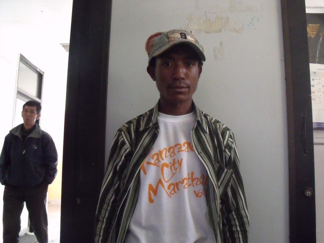 クリシュナがのろのろと遅い早く行って乗れるように頼みこまなければと思っているのに遅い、<br />スターバックスならぬスターバラックの看板（真中の絵柄がアマダブラになっている）を<br />撮っておきたいのに、待ち切れずに通過する。<br /><br />１３：３０ルクラ空港着　問題の鼻ぺちゃ飛行機はまだ直している様子もなく、邪魔な位置に置いてある。空港内はいっぱいの人先頭部分にも荷物をいれれるようで、お米らしき袋を詰め込んでいる。係員らしき人に券を見せ、テイクミーと腕をとる。<br />AGN航空へ連れられて、明日の予約をキャンセルして、今日の便に乗せてくれるようになる。<br />今出発する飛行機が、２５分でカトマンズまで行き、帰ってくれば乗れると言う。<br /><br />クリシュナにあげる物を渡し、２２日分の残り５０００RPとジリまでの帰り分３日分をチップとして支払う。いいガイドとは言えなかったが、いい奴だった。<br />金沢市民マラソンのTシャツを着ているポーターがいたら、声をかけてやって下さい。<br /><br />♪ルクラ離れ離れになろうとも、山行仲間はいつまでもぉー♪（行高山念生）<br />これがまあ　ついの終わりか　ルクラの空<br /><br />