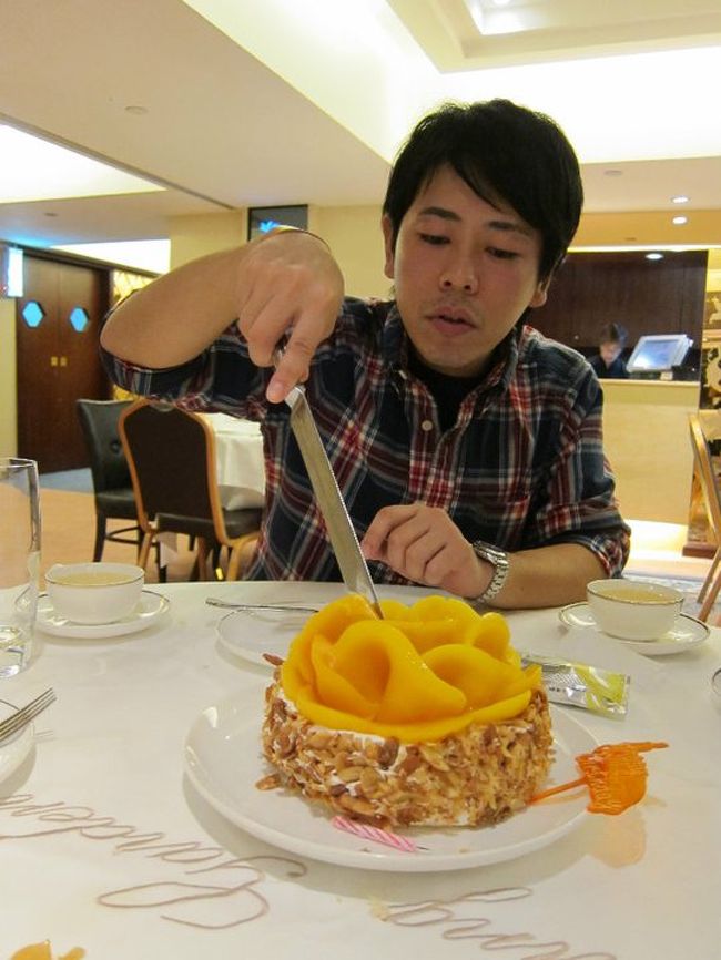 デカいナイフで、願い事をしながら切るのが香港式？<br /><br />一カ所を切ると、後は店員さんが切り分けてくれます。<br /><br />マンゴーケーキでした！