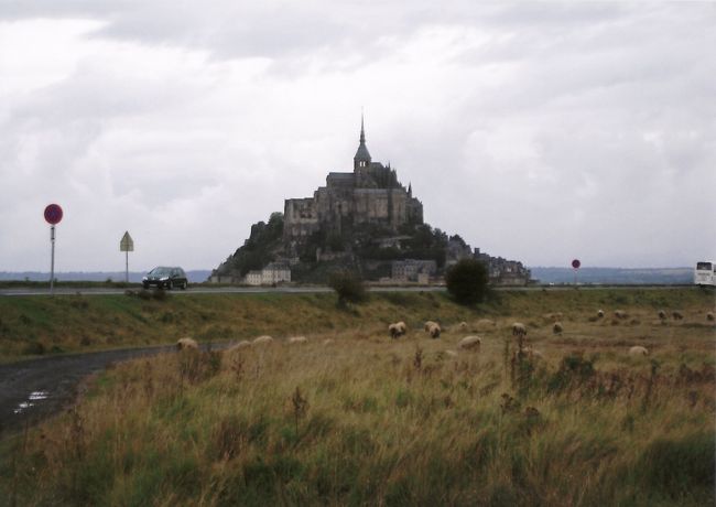 やっとお昼ごろにモンサンミッシェルに到着。記念撮影ポイントへ。対岸の村のあちこちに工事現場が見られます。数年後には島まで橋ができるため、駐車場を対岸に作っているそうです。そのころにはこの撮影ポイントはもう入れないしモンサンミッシェルの写真は撮りにくくなるだろう・・とガイドさんは言ってました。<br />それにしても、世界遺産に来たのは何か所目？ビクトリアでここを描いた絵を見てから４年！世界不思議発見や世界遺産の番組で見たところに本当にこれて、本当にHappyです。