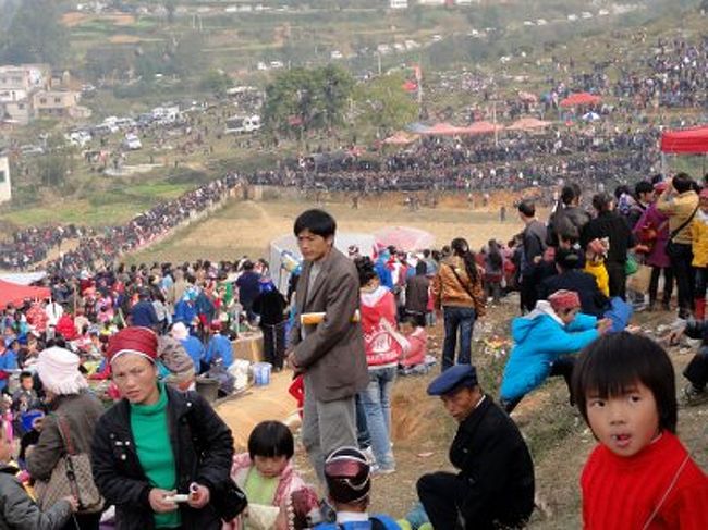 　丘の上にいるのは、半分は商品やスナックを芝生の上に広げて商売する人。サイコロゲーム(魚蝦蟹の一種)のテキヤの人もいます。それ以外の人は、ただ、地面に座って友達をおしゃべりするだけ。集団ピクニックといったところです。ここより、さらに人口密度が高い場所もあります。それは、すぐ隣にある闘牛場。丘の下に四角い堀があり、その周りを物凄い数の男性が囲んでいます(写真奥)。