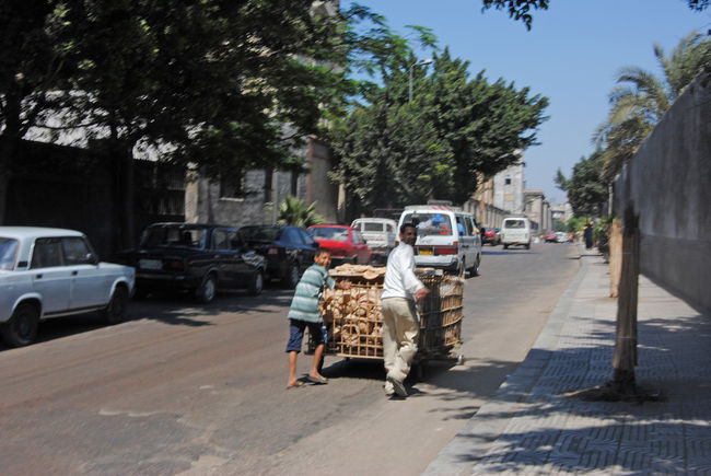 木製の台車でパンを運ぶ親子