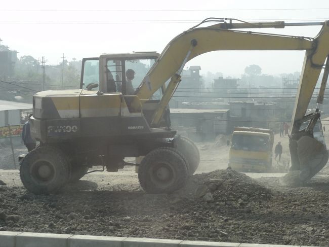 チベットに続くこの道は現在日本の援助で改修中。<br />あちこち工事中で、渋滞も多く、気をつけないといろんなところに頭を打ち付ける。<br />完成すると立派な道路になりそうだ。「HAZAMA]の看板がいたるところにある。<br />日本製の「はたらくじどうしゃ」フル回転。