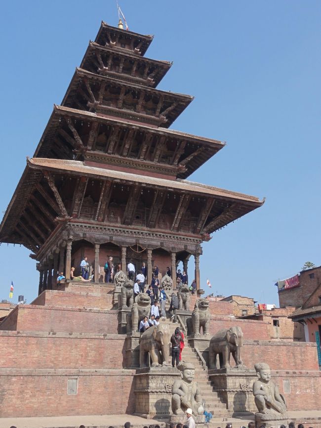 トウマディー広場から見るニャタポラ寺院。<br />急な階段の上にたくさんの人。<br />