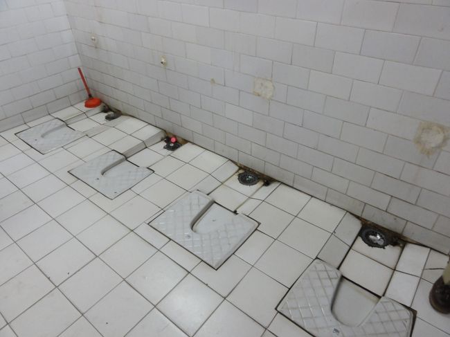 トイレに行ってみると、こんなのが！<br />ドアのついた洋式トイレは２つだけ。幸いすいていたのでそちらを利用したが、なぜか水が出ない。<br />足元に水の出る蛇口とバケツがあったので、水をためて流す。<br />手を洗う水も出ない。<br />こんなこともあろうかと持ち歩いているウェットティシューで手をふく。<br />でも、このトイレ普通の男性用トイレの女性バージョンだと思えば、使えないこともなさそう。<br />切羽つまったときは使うだろう。できれば何人かで「せーのー」って勢いで。