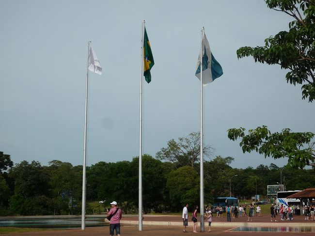 イグアス国立公園入り口。「ブラジル側のイグアス国立公園はブラジル南部パラナ州の西部に位置。1939年に設置された約1850平方??の広さを持つ国立公園。1984年にアルゼンチン側の国立公園も含めてユネスコの世界自然遺産に登録された。ブラジル側のイグアスの滝は、ブラジル側公園入り口からバスに乗り、バス停で降りて、滝の眺めを見ながらの散策になる。アルゼンチン側に滝が多く有るため、近くから眺めることはあまり出来ないが、美しいイグアスの滝の全景を観察することが出来る。ブラジル側の滝観光にはブラジル入国ビザが必要で、悪魔の喉笛周辺の眺めが望めるだけではなく、ベンジャミン、コンスタント、デオドロ、フロリアーノ、サンタ・マリア滝などを観察することが出来る（文野旅行社HPより）。 