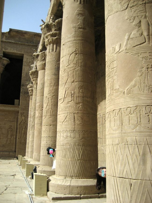 そこに10才くらいの男の子がキャッチセールスに来た。 <br />「オール＄1」(米ドルも使える) んなワケ無いが、一応着いて行く。 <br />14才くらいのお姉ちゃんが店番してるそこは他店と比べると、なおさら良い物が無い。 <br />無理矢理選んでいくらか聞くとやっぱり、＄10とか言いやがる。 <br />「おめー＄1って言ったしょ!」日本語で凄む(子供相手に…)。 <br />男の子「うん、＄1」…どうやら意味も解らず言わされてるようだ。 <br />品揃えは悪いが他より安いのは否めない。 <br />現地通貨で約￥380に負けさせ、ついでに帽子(髪飾り?)を＄1で買う。 <br /><br />↑おなつとるるる、柱に埋もれる 