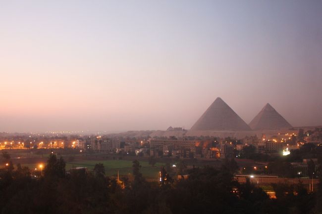 右手を見ると・・・今朝はピラミッドもくっきり。<br /><br />ギザの街のかすかなライトアップが残る中での朝のピラミッド。カイロから遠く離れた交通不便な宿でしたが、この光景を見られただけで、宿泊してよかったと感じました。