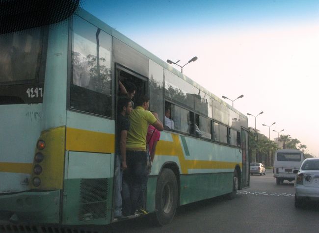 これもタクシー乗車中の一コマ。<br /><br />左側のバスには人があふれんばかりに乗車しています。<br /><br />このときのドライバーは話好きで、日本車の性能の話題（韓国製や中国製に比べて壊れにくいとか、ＴＯＹＯＴＡのランドクルーザーに乗りたいとか）やカイロの地下鉄建設に日本企業が携わっているといった話など、日本のことをいろいろほめたてられました。<br />（このタクシーはＨＹＵＮＤＡＩでしたが。）<br /><br />チップ要求のためなのかな〜と勘繰りつつも、会話を楽しめました。<br />お互い英語が片言同士だとよく通じるものですね。