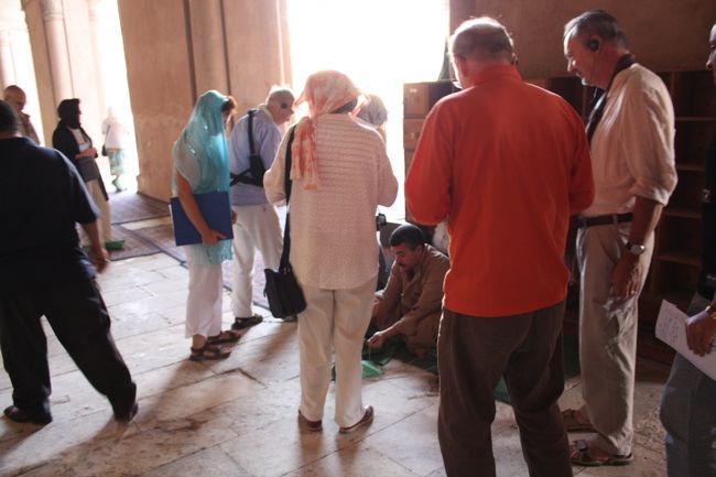 中に入ると、先にフランス人の団体客が来ていて、おじさんに靴カバーをかけてもらっているところでした。<br />写真の女性はスカーフを着けていますが、モスクに入るときは異教徒でもスカーフを着用しなければなりません。<br /><br />このあと、自分もカバーをかけてもらいました。<br />バクシーシを要求されたので、地球の歩き方に書いてあったとおり５０pt.（７．５円）を払ったところ、おじさんは特に表情を変えもせず、何も言わずに通してくれました。<br />満足だったのかどうか・・・。