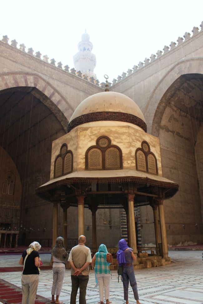 中庭に出てみました。<br /><br />天井は吹き抜けになっており、中央には巨大な泉亭が置かれています。<br /><br />そして中庭の周りには巨大なイーワーン（一方が完全に開き、三方が壁で囲まれ、天井がアーチ状となっている空間。もともとイスラム化以前のササン朝ペルシャ（226-651年）の土の文化に根ざした伝統建築であった。）があり、四方を取り囲んでいます。<br /><br />イーワーンの中でもこのように中庭の中心軸上に四つのイーワーンを設ける様式をチャハール・イーワーンといい、１２世紀のセルジューク朝の時代にイーワーンが建てられたイスファハンの金曜モスクなど、中世ペルシャを中心としたモスクの一様式となっています。<br /><br /><br />このイーワーン建築は１２〜１４世紀にインドからエジプトまで大流行したそうで、隊商・商船貿易の発展やモンゴル帝国の拡大などで東西の交流が活発になったことを表しているのでしょう。<br /><br />モロッコのタンジェ出身で“三大陸周遊記”を著した旅行家イブン・バットゥータ（1304-68年）もこのころ活躍していますよね。<br />西洋史で言えばヴェネツィア商人のマルコ・ポーロ（1254-1324年）も。