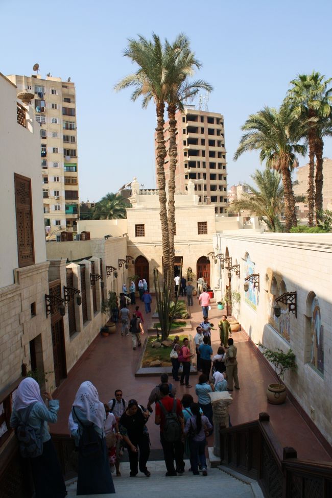 内部の見学が終わり、中庭に出てきました。<br /><br />社会科見学でしょうか、白いスカーフをまいた女学生がたくさんいます。<br />中には大胆にもスカーフを脱いでいる娘もいて・・・ということはコプト教徒なんでしょうか。<br /><br />彼女らはアジア人が珍しいのか、そもそもよそ者や男性には厳しいのか、硬い顔つきでおそるおそる“ハ〜ロ〜”と声をかけてきます。<br /><br />そんな顔されたらこちらも表情が崩れず、硬いままハローと返してしまいますよ（笑）。