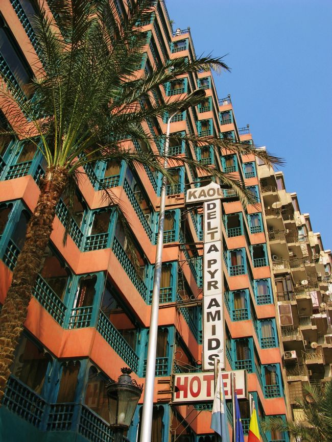 オールドカイロから約４０分、１３時前にホテルに到着。<br />タクシー代は交渉で決めた４０£Ｅ（６００円）。<br /><br />ドライバーは無口な若者で、ちゃんとメーターもまわしてくれていて、メーターの額はこれよりも少なかったですが、端数はチップと思って交渉で決めた額をそのまま渡しました。<br />なので、それ以上のチップ要求もありませんでした。<br /><br /><br />時間に余裕があったので、宿泊した記念にホテル・デルタ・ピラミッドをパチリ。<br /><br />この形、イスラム建築を見た後ではムカルナス（イスラム建築特有の鍾乳石や蜂の巣の形をした有機的な襞状の装飾）を意識してつくったのかなと思えてしまいます。