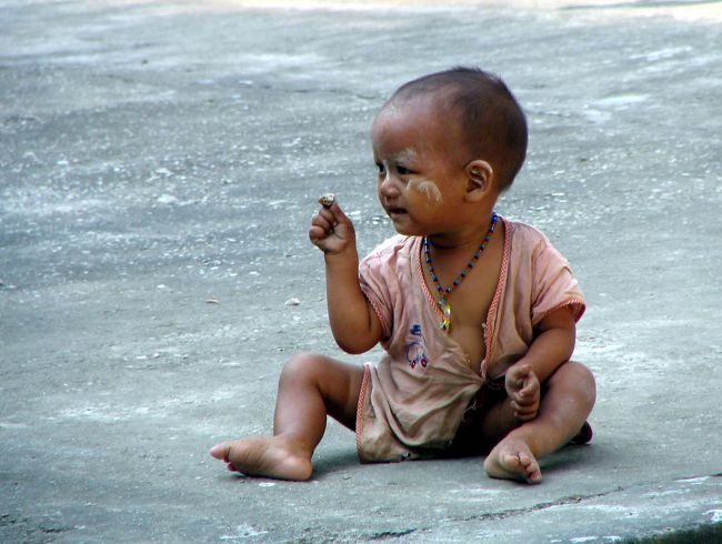 ミングオンで遊ぶ幼児も白いタナカを頬にぬてもらっていました。<br />2004年、ミャンマー