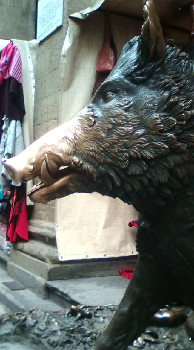 有名ないのししさん。みんな手で触っているところを記念撮影していました。もちろん私も触ってきました^^　後ろにちらっと見えるのは出店。かばんやら、スカーフやら…　赤いかばんが魅力的でした。