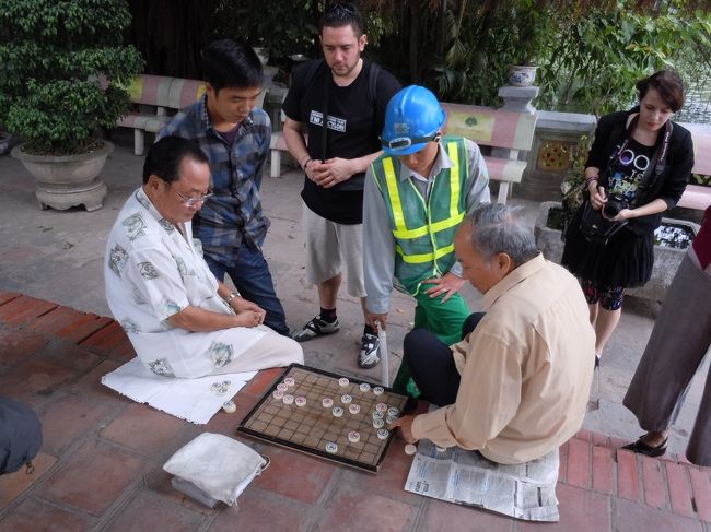 日本で言うと将棋的なものかと<br /><br />なぜ外でやるのじゃ・・・<br /><br />不忍池のほとりで将棋やってるおじさん集団を思い出した