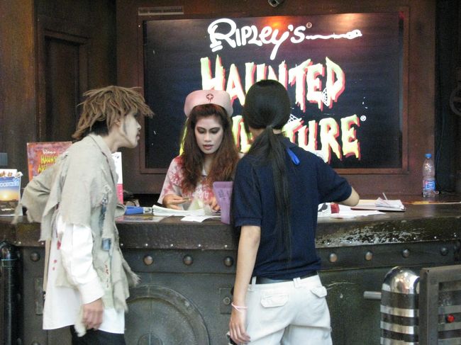 スリラーハウスの受付には、ゾンビまがいのナースの格好をした係員がいました。<br />手前の男性も係員です。