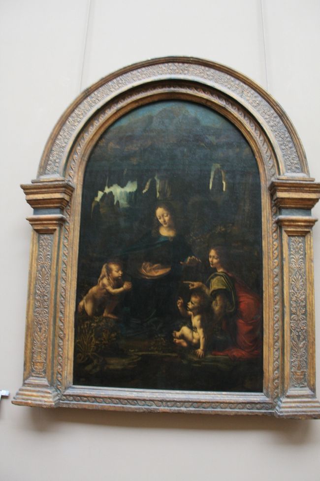 『岩窟の聖母 ルーヴル版 』<br />本来、ミラノのサン・フランチェスコ・グランデ聖堂の礼拝堂を飾る作品でだったのが、当時、レオナルドとこの祭壇画の依頼主との間でトラブルがあり、それを仲裁したルイ12世に献上したとされる作品。