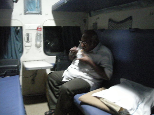 私たちは寝台列車。<br />隣のおじさんが写真を取らせてくれました。<br />大きな体で、小さなカップに入ったトマトスープを飲んでます。<br /><br />インドの寝台列車では、チャイと並んでトマトスープがよく売られてました。