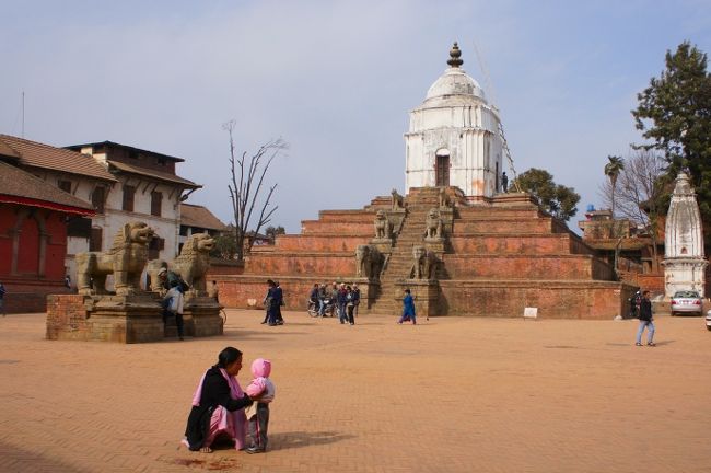 バクタプル観光の最初は旧王宮や寺院が立ち並ぶ、ダルバール広場。<br /><br />東側からアプローチ。白いのはファシデガ寺院。<br />観光客よりも地元の方が多いのがいいですね。<br /><br />写真左側にちょっと見えている茶色い建物が、５５窓の王宮です。