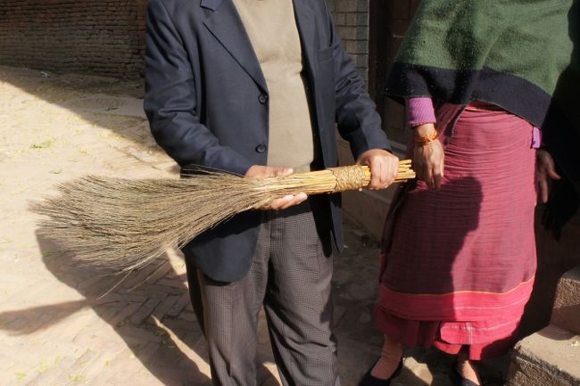その家の前、道を清めていた人。ほうきを見せてくれました。