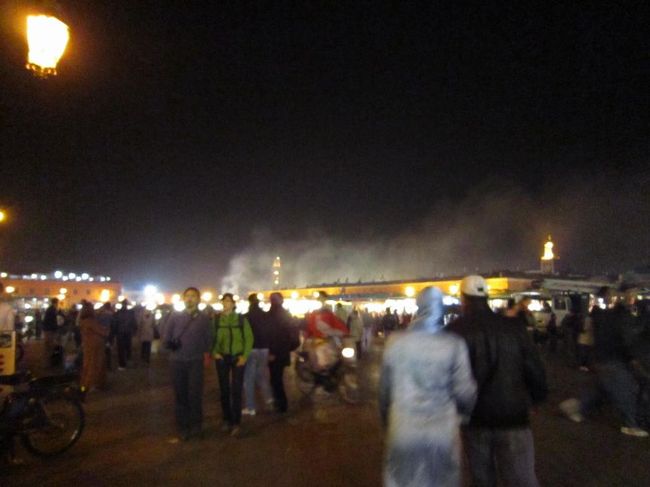 晩御飯を食べにジャマエルフナ広場へ。<br />ホテルのスタッフにジャマエルフナでは不衛生だから色々食べないようにと注意された。分かった！と適当に返事をして出掛けた。<br />リヤドから広場まで１５分ほど。夕暮れ時で少し不安なところへ子供が道を教えようかとついてくる。ガイドブックによれば後からガイド料を請求されたりめんどくさいと書いてあったので足早に去る。<br /><br />「ジャマエルフナ広場」は旧市街の中心にあり、屋台や大道芸人や観光客で賑わっている。大道芸人は写真を撮っていると金を寄こせとうるさいらしいので撮ってはカメラをしまうを繰り返す。