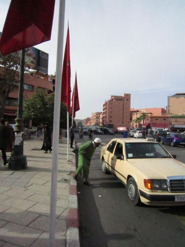 旧市街まで１本で行けるバスがあったのでバス停らしき所でバスを待つ。でもバス停の標識が無いんだよな〜。<br /><br />見ているとタクシーは乗り合いもOKらしい。お客さんを乗せたタクシーに声を掛けて乗り込む人も多い。どうやってお金の計算するんやろ。<br />このおじさんが来ているのはモロッコで良く見かけるファッション「ジュラバ」すっぽり被るワンピース風の服で、ねずみ男みたいな帽子がついていて被っているおじさんを良く見かけた。