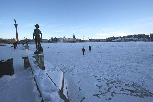 市庁舎を訪れた観光客が凍った運河を歩いていきます。
